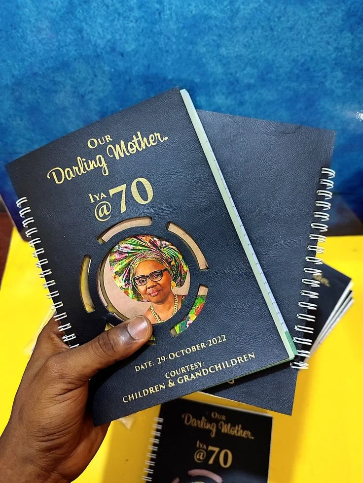 Black spiral notebooks with a gold seventieth birthday design