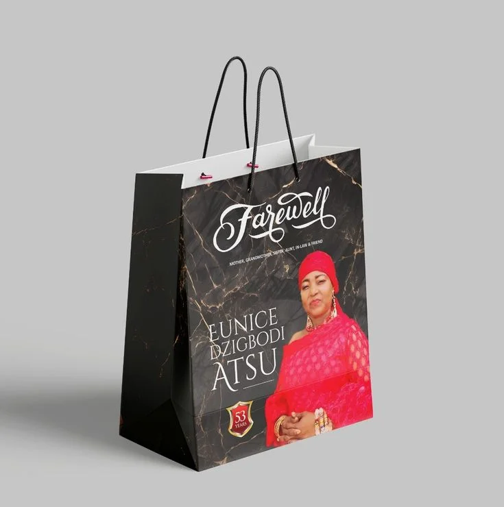 Black commemorative shopping bag with a portrait and gold lettering