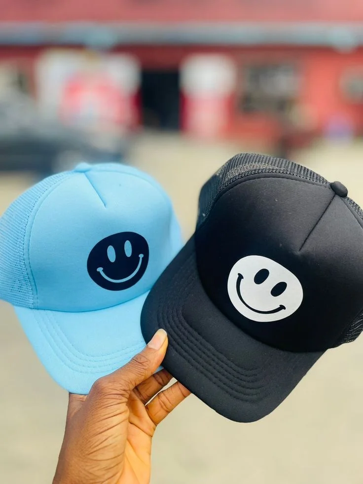 Blue and black baseball caps with contrasting smile graphics